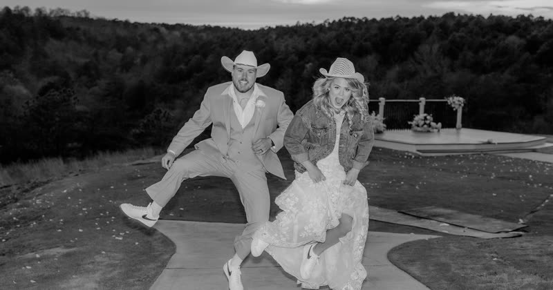 A couple caught mid-jump outdoors after their ceremony.