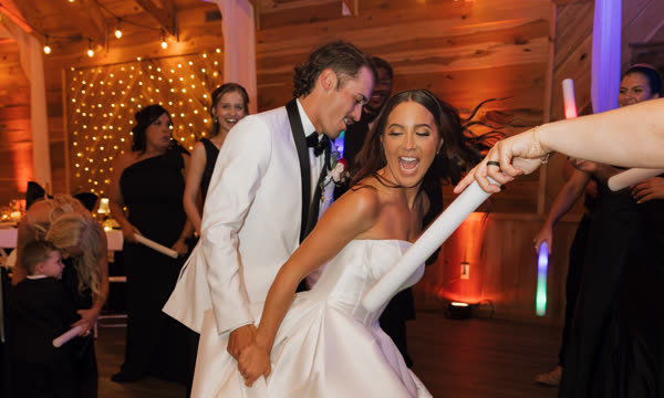 A couple dancing in a room lit with coloured uplighting.